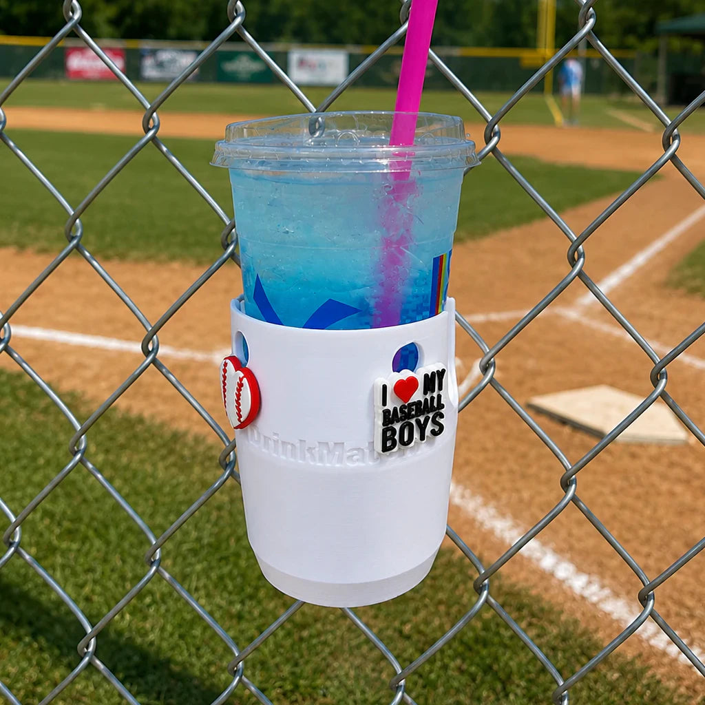 Drink Mate in white mounted on a fence holding a blue beverage with Crocs Jibbitz attached.